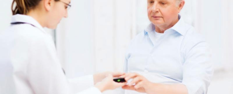 Un médecin qui mesure la glycémie d'un patient à l'aide d'un glucomètre